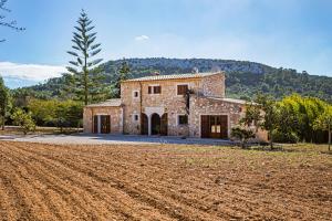 a large stone house with a field in front of it at Son Peris in Caʼs Concos