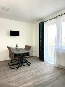 a dining room with a table and chairs and a window at Sky Apartments 502 in Plzeň