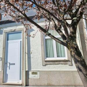 un bâtiment avec une porte blanche et un arbre dans l'établissement Honey House, à Matosinhos