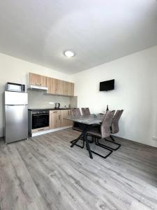 a kitchen with a table and chairs and a refrigerator at Sky Apartments 502 in Plzeň