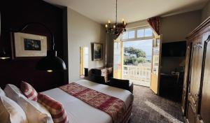 een slaapkamer met een bed en een groot raam bij Hôtel-Restaurant Printania in Dinard