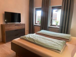 a bedroom with two beds and a flat screen tv at Grünnest in Harpstedt