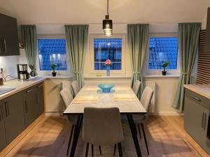 a kitchen with a table and chairs and windows at Grünnest in Harpstedt