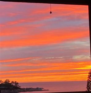 a sunset view from the window of a house at porto frailis Arbatax casa vista mare in Àrbatax