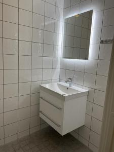 a white bathroom with a sink and a mirror at Grünerløkka Deluxe Apartments in Oslo
