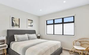 a bedroom with a bed and a window and a chair at BeachTownhouse779 in Rosebud
