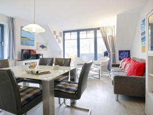 een eetkamer en een woonkamer met een tafel en stoelen bij Papillon Whg Pa13 5 in Boltenhagen