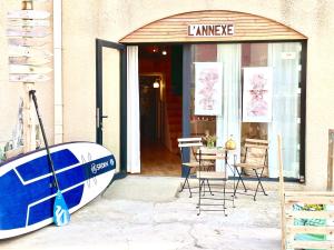 una tienda con una tabla de surf delante de una puerta en L'Annexe de la Madrague Marseille, en Marsella