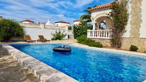 a swimming pool in front of a house at MEDDAYS VILLA SOL in Miami Platja