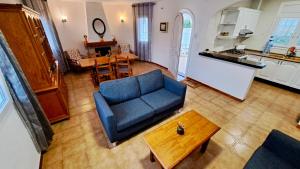 a living room with a blue couch and a table at MEDDAYS VILLA SOL in Miami Platja