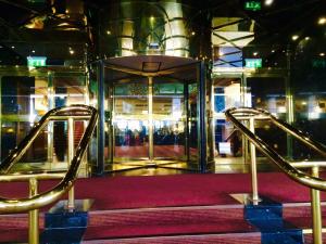 una puerta de cristal abierta en una escalera de moqueta roja en Britannia International Hotel Canary Wharf, en Londres