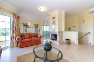 a living room with a red couch and a fireplace at Casa Presa da Moura in Carvoeiro