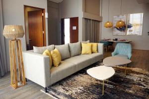 een woonkamer met een bank met gele kussens bij The Balcone Suites & Resort Powered by Archipelago in Bukittinggi