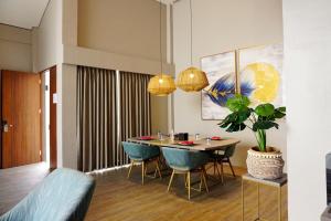 武吉丁宜的住宿－The Balcone Suites & Resort Powered by Archipelago，一间带桌子和蓝色椅子的用餐室