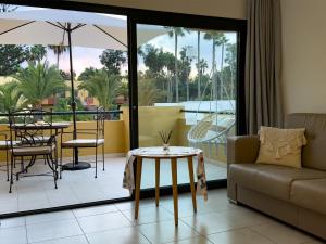 Villa Rosa Fuerteventura في كوراليخو: غرفة معيشة مع أريكة وطاولة