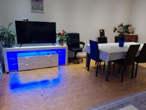 sala de estar con TV y mesa con sillas en PORTE DE FRANCE en Estrasburgo