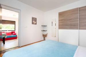 a bedroom with a blue bed and a couch at Apartment in Vrbnik/Island Krk 35842 in Vrbnik