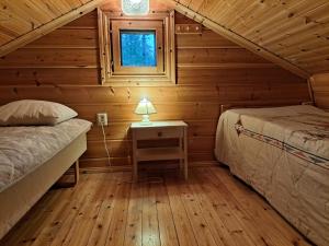 a bedroom with two beds in a log cabin at Nelisyöte A in Syöte