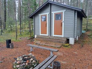 a small cabin with a bench in the woods at Nelisyöte A in Syöte