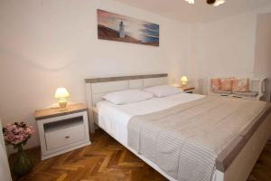 Un dormitorio con una gran cama blanca con dos lámparas. en Apartment in Vrbnik - Insel Krk 36848, en Vrbnik