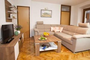 ein Wohnzimmer mit einem Sofa und einem Tisch in der Unterkunft Apartment in Vrbnik - Insel Krk 36848 in Vrbnik