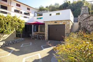 un aparcamiento con garaje y un edificio en Apartment in Vrbnik - Insel Krk 36848, en Vrbnik