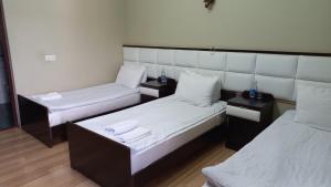 a room with two beds and two night stands at Kefilyan Family Hotel in Haghpat
