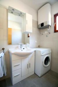 Un baño con lavabo y lavadora. en Apartment in Vrbnik - Insel Krk 36848, en Vrbnik