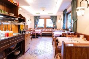 a restaurant with tables and chairs in a room at Hotel Garni Rin Da Rin in Livigno