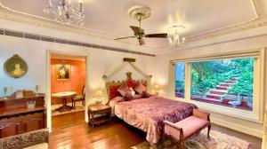 a bedroom with a large bed and a large window at Ramsukh Resorts and Spa in Mahabaleshwar
