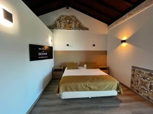 NadadouroAlojamento Local Monte Horeb的一间卧室，墙上有一张床和一块牌子