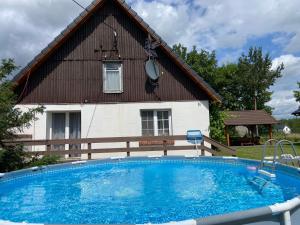 a large swimming pool in front of a house at Domek nad jeziorem Bory Tucholskie las jeziora wakacje weekend Błądzim in Błądzin