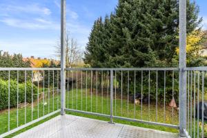 einen Balkon mit einem Zaun und einem Baum in der Unterkunft CASSEL LOFTS - Komfortable Wohnung für 4 mit Balkon nahe VW-Werk in Kassel