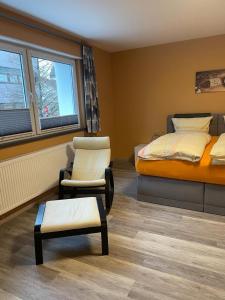 sypialnia z łóżkiem, krzesłem, łóżkiem i fotelem w obiekcie Boarding House Zweibrücken w mieście Zweibrücken