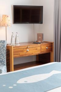 a wooden desk with a television on top of it at Hotel Residence Les Medes in Porquerolles