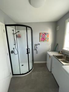 a bathroom with a shower with a glass door at Minimalist Cabin Solo Traveller in Ashburton