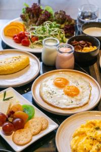 a table with plates of breakfast food on it at Ramada Plaza by Wyndham Bangkok Sukhumvit 48 in Bangkok