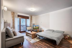 1 dormitorio con 1 cama y 1 sofá en Apartment Amelia Tale-Wellness 5 min-Chopok-View-Balcony-Washer-Hiking, en Horná Lehota