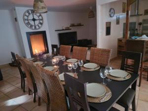 a dining room with a table and chairs and a clock at Villa de 2 à 10 personnes tarif en fonction du nombre de personnes in Vonnas