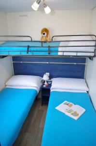 two twin beds in a room with a blue bed at Happy Camp mobile homes in BalatonTourist Füred Camping & Bungalows in Balatonfüred