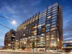 duży budynek biurowy z wieloma oknami w nocy w obiekcie Stylish , CBD , Views w Melbourne