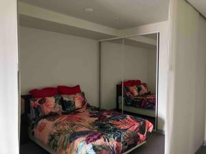 sypialnia z łóżkiem i dużym lustrem w obiekcie Stylish , CBD , Views w Melbourne