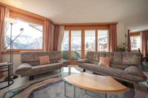 ein Wohnzimmer mit 2 Sofas und einem Tisch in der Unterkunft Casa Cresta C32 - Panoramablick in Arosa