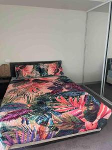 łóżko z kolorową kołdrą w sypialni w obiekcie Stylish , CBD , Views w Melbourne