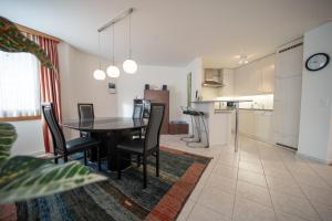 eine Küche und ein Esszimmer mit einem Tisch und Stühlen in der Unterkunft Casa Cresta C32 - Panoramablick in Arosa