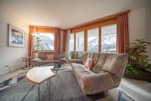 ein Wohnzimmer mit einem Sofa und einem Tisch in der Unterkunft Casa Cresta C32 - Panoramablick in Arosa