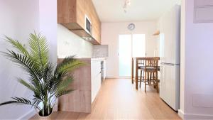 una cocina con paredes blancas y una planta en una olla en La Torre - terraza y vistas al mar, en Torre de la Horadada