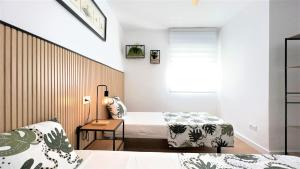 Un dormitorio con dos camas y una ventana. en La Torre - terraza y vistas al mar, en Torre de la Horadada