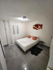 een slaapkamer met een wit bed in een kamer bij Chambres dans Maison à Herblay sur seine in Herblay