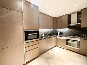 ドバイにあるLuxury Stay At Five Palm Residenceのキッチン(木製キャビネット、ステンレス製の電化製品付)
